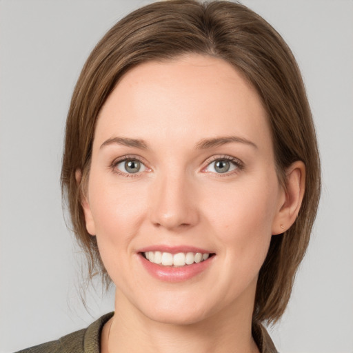 Joyful white young-adult female with medium  brown hair and grey eyes