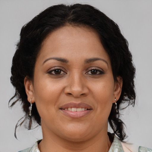 Joyful latino adult female with medium  brown hair and brown eyes