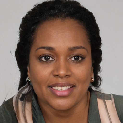 Joyful black young-adult female with long  brown hair and brown eyes