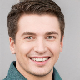 Joyful white young-adult male with short  brown hair and grey eyes