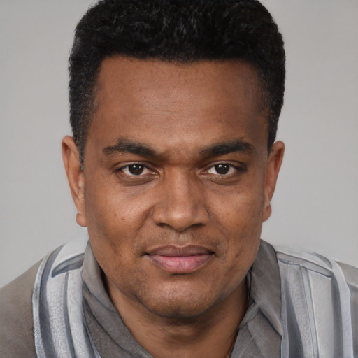 Joyful black young-adult male with short  black hair and brown eyes