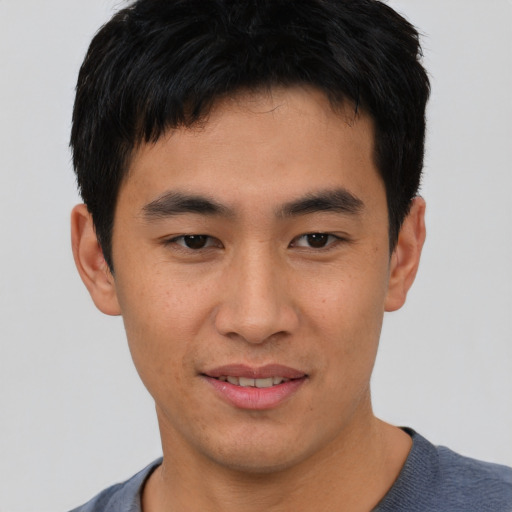 Joyful asian young-adult male with short  black hair and brown eyes