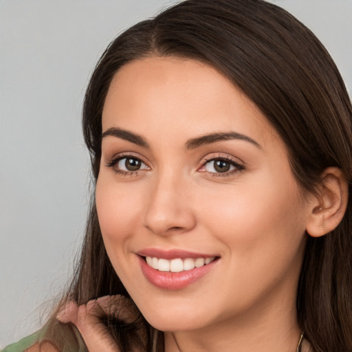 Joyful white young-adult female with long  brown hair and brown eyes