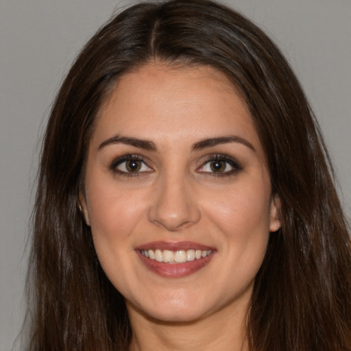 Joyful white young-adult female with long  brown hair and brown eyes