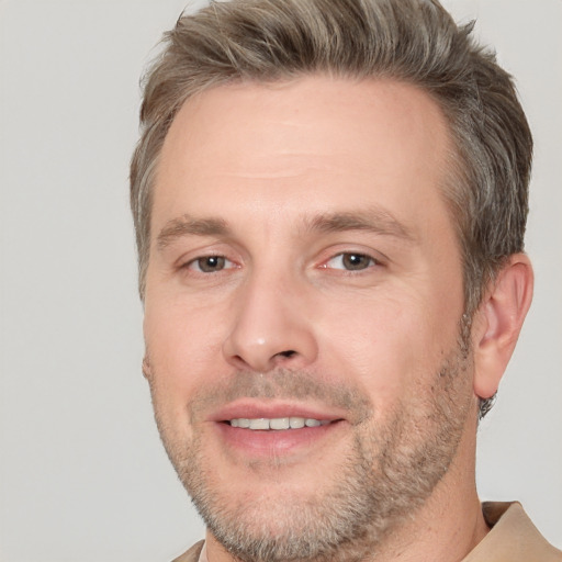 Joyful white adult male with short  brown hair and brown eyes