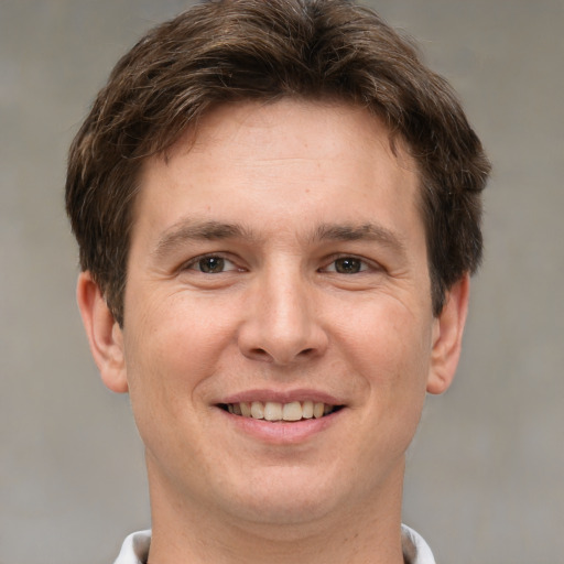 Joyful white adult male with short  brown hair and brown eyes