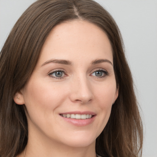 Joyful white young-adult female with long  brown hair and grey eyes