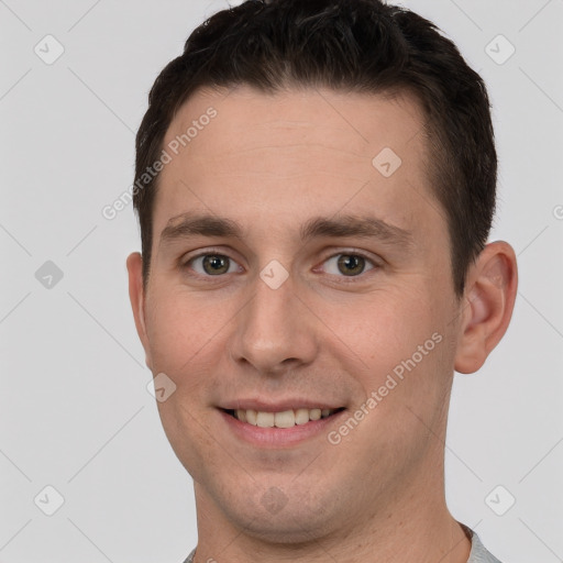 Joyful white young-adult male with short  brown hair and grey eyes