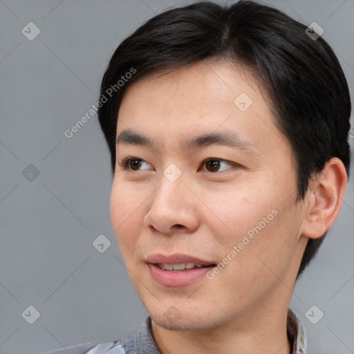 Joyful asian young-adult male with short  brown hair and brown eyes