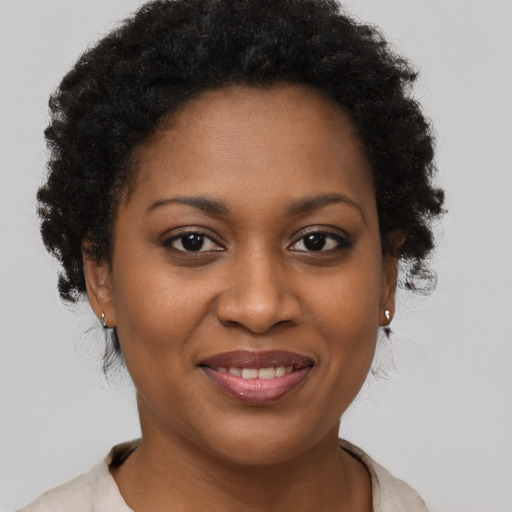 Joyful black young-adult female with short  brown hair and brown eyes