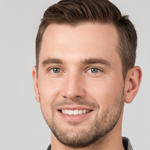 Joyful white young-adult male with short  brown hair and grey eyes