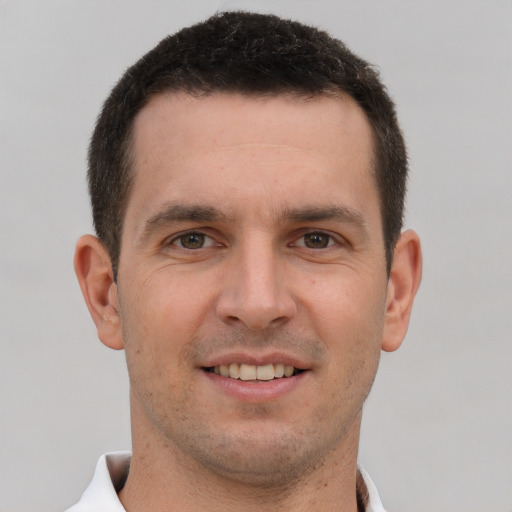 Joyful white young-adult male with short  brown hair and brown eyes