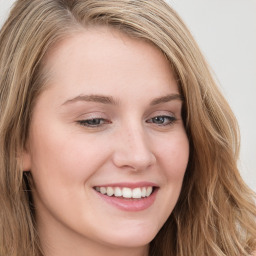 Joyful white young-adult female with long  brown hair and blue eyes