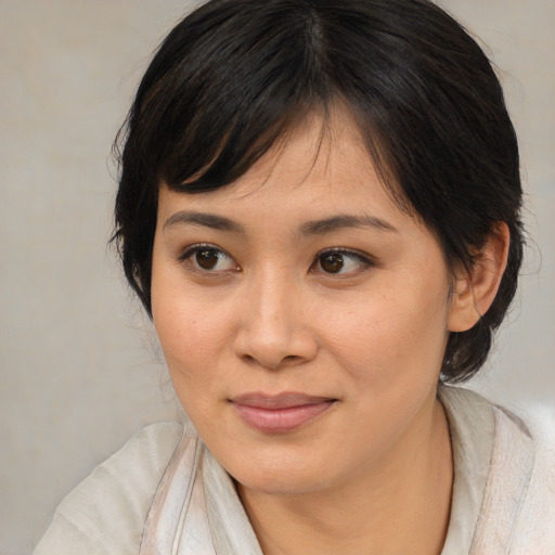 Joyful asian young-adult female with medium  brown hair and brown eyes