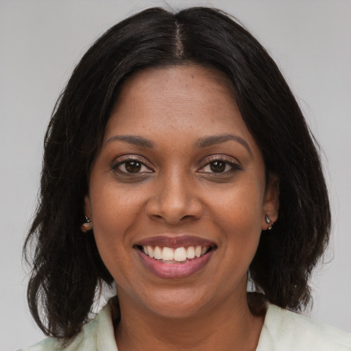 Joyful black young-adult female with medium  brown hair and brown eyes