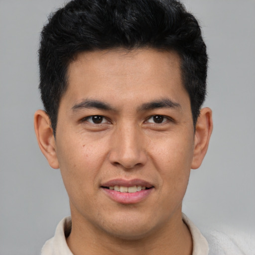 Joyful latino young-adult male with short  brown hair and brown eyes