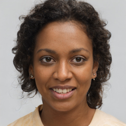 Joyful black young-adult female with medium  brown hair and brown eyes