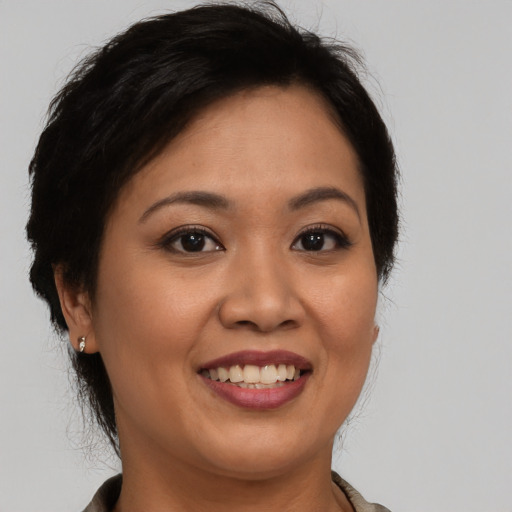 Joyful latino adult female with medium  brown hair and brown eyes