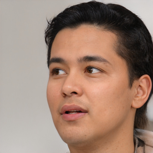 Joyful asian young-adult male with short  brown hair and brown eyes