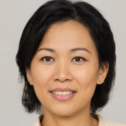 Joyful asian adult female with medium  brown hair and brown eyes