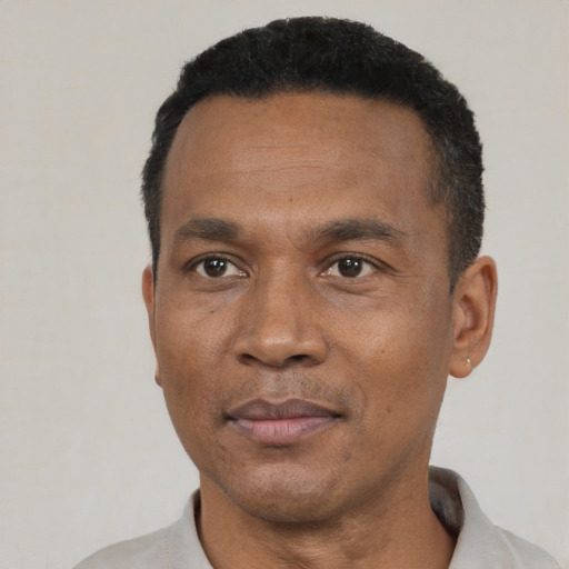 Joyful black adult male with short  black hair and brown eyes