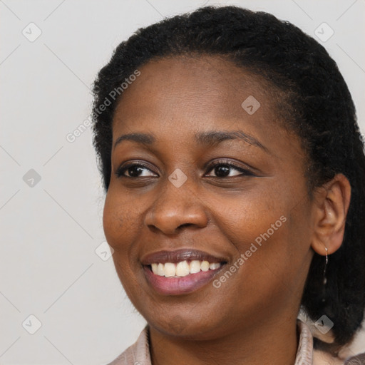 Joyful black young-adult female with long  brown hair and brown eyes