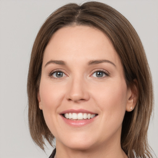 Joyful white young-adult female with medium  brown hair and grey eyes