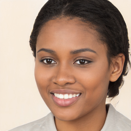 Joyful black young-adult female with long  brown hair and brown eyes