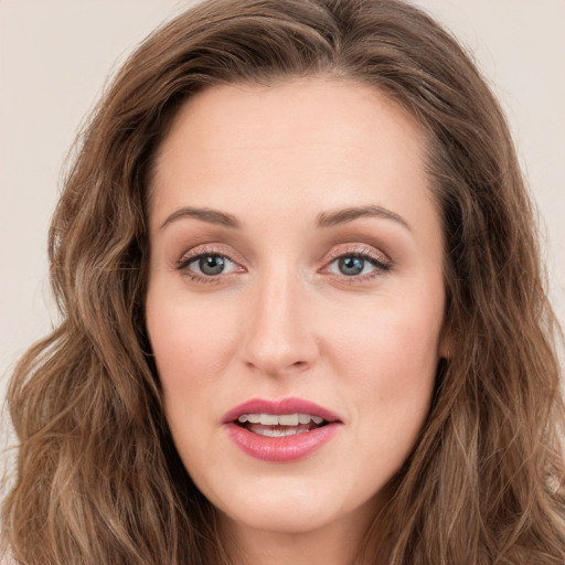 Joyful white young-adult female with long  brown hair and blue eyes