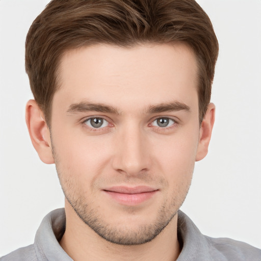 Joyful white young-adult male with short  brown hair and grey eyes