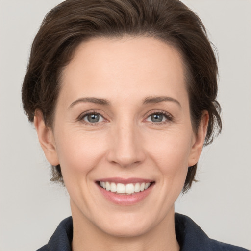 Joyful white young-adult female with medium  brown hair and grey eyes