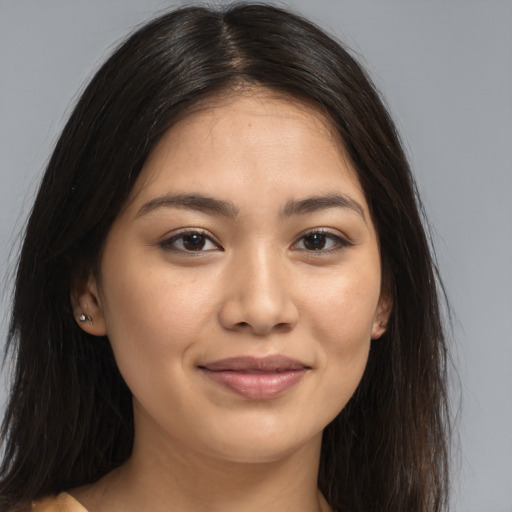 Joyful latino young-adult female with long  brown hair and brown eyes