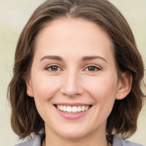 Joyful white young-adult female with medium  brown hair and green eyes