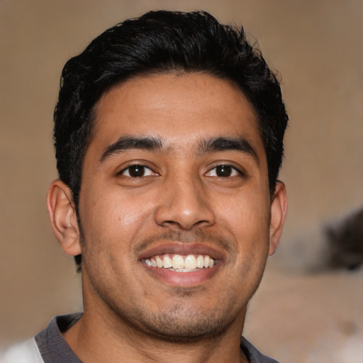 Joyful latino young-adult male with short  black hair and brown eyes