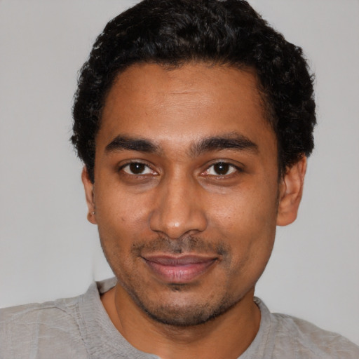 Joyful black young-adult male with short  black hair and brown eyes