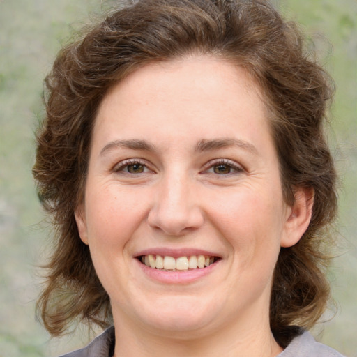 Joyful white young-adult female with medium  brown hair and green eyes