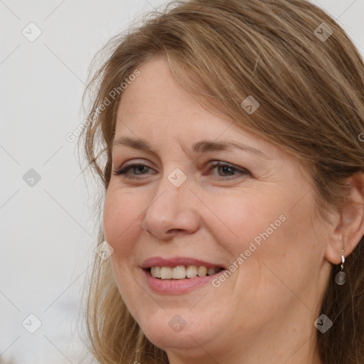 Joyful white adult female with medium  brown hair and grey eyes