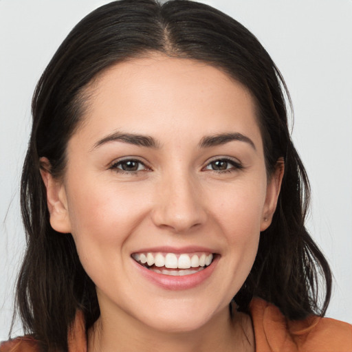 Joyful white young-adult female with long  brown hair and brown eyes