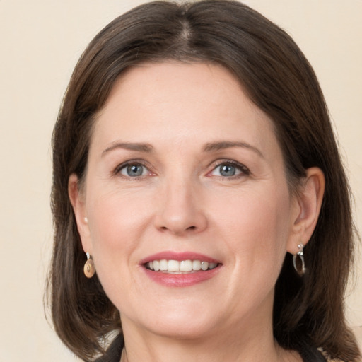 Joyful white adult female with medium  brown hair and grey eyes