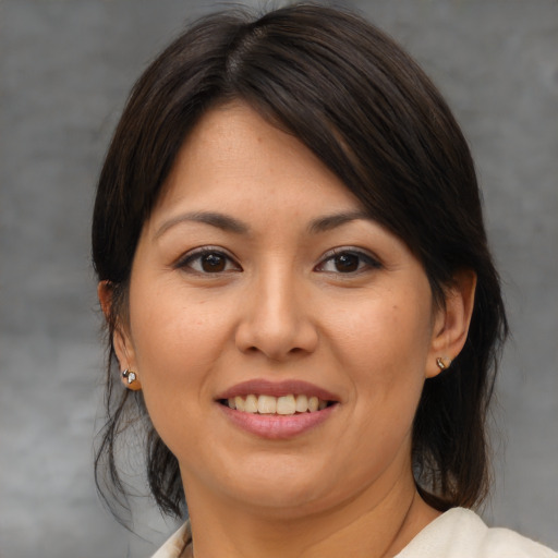 Joyful asian adult female with medium  brown hair and brown eyes