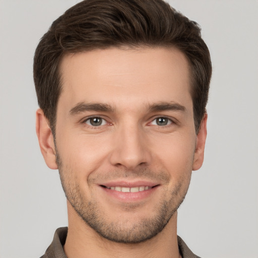 Joyful white young-adult male with short  brown hair and grey eyes