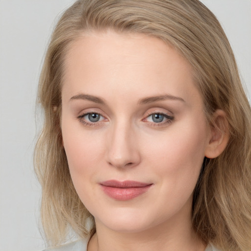 Joyful white young-adult female with long  brown hair and blue eyes