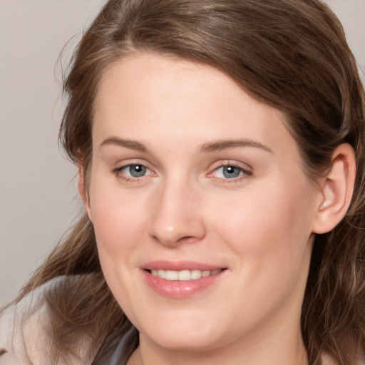 Joyful white young-adult female with medium  brown hair and grey eyes