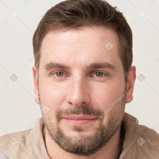 Joyful white young-adult male with short  brown hair and grey eyes