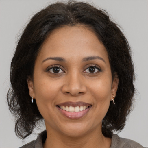 Joyful latino adult female with medium  brown hair and brown eyes