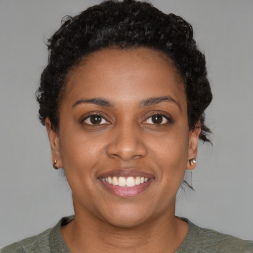 Joyful black young-adult female with short  brown hair and brown eyes