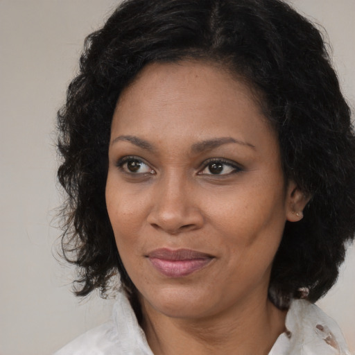 Joyful black adult female with medium  brown hair and brown eyes