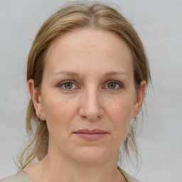 Joyful white adult female with medium  brown hair and grey eyes