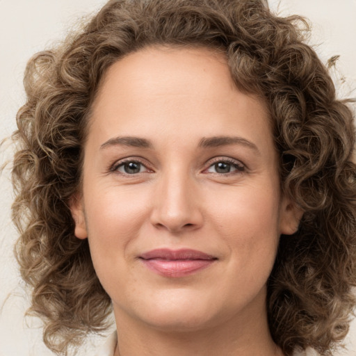 Joyful white young-adult female with medium  brown hair and green eyes