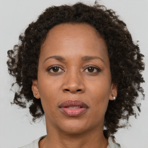 Joyful black adult female with medium  brown hair and brown eyes